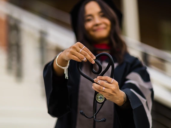 Alia holding her stethoscope as a heart