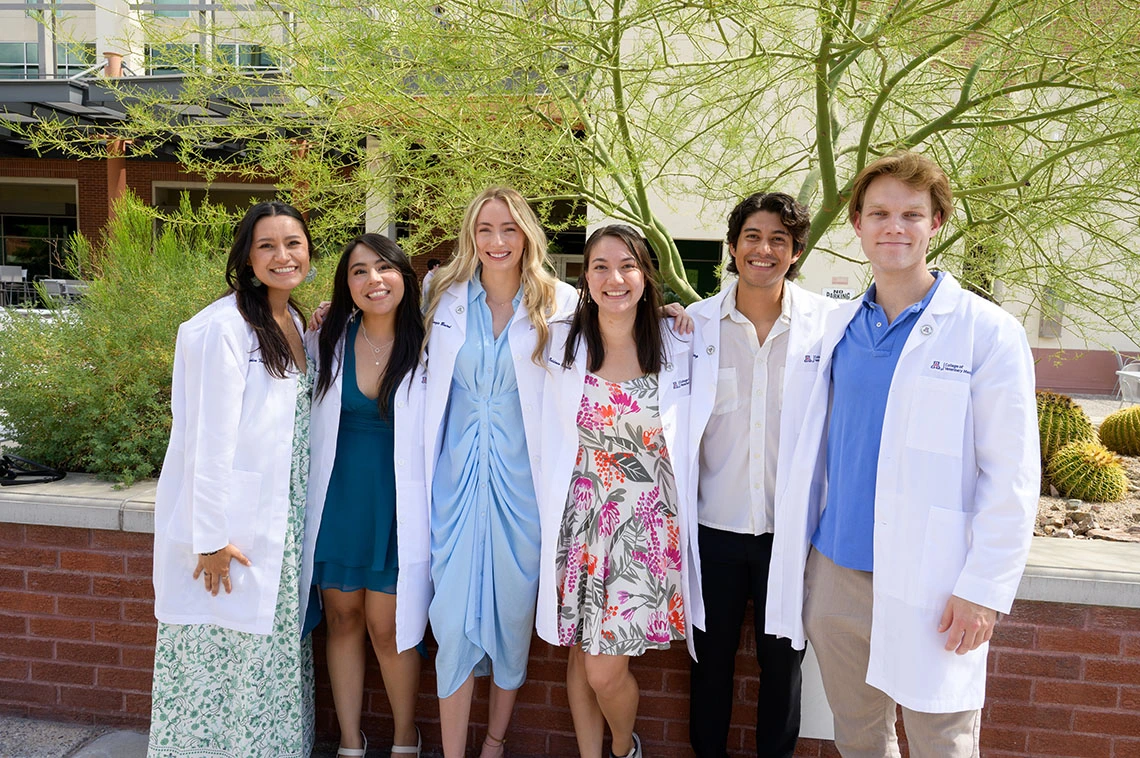 students at the white coat ceremony smiling together