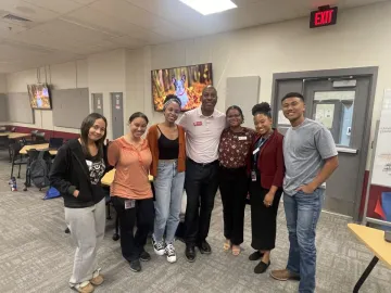 Six students and one professor pose together.