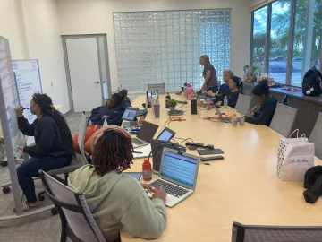 Club members sit around a large conference table.